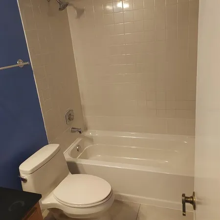 a bathroom with a granite countertop toilet and a sink