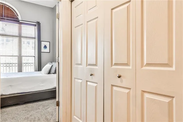 a view of a brick house with large windows and a small yard