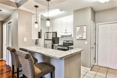a kitchen that has a table chairs and a refrigerator