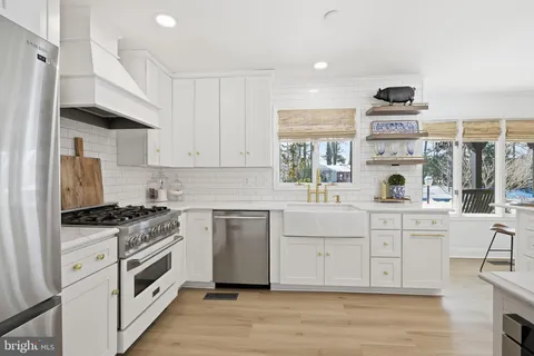 a kitchen with stainless steel appliances granite countertop a stove and white cabinets