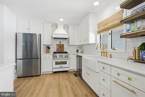 a kitchen with cabinets stainless steel appliances and sink