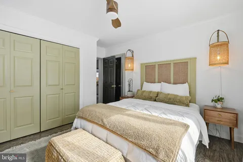 a bedroom with a large bed and wooden floor