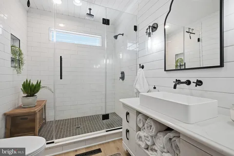 a bathroom with a sink a toilet and shower