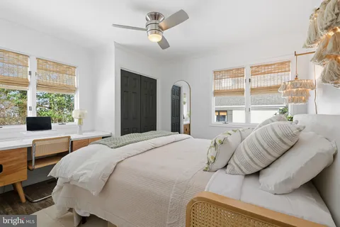 a bedroom with a bed a large window and potted plant