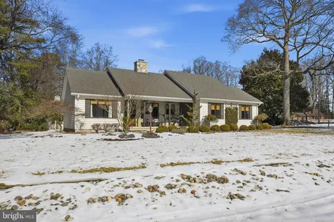 a view of a house with a yard covered in snow