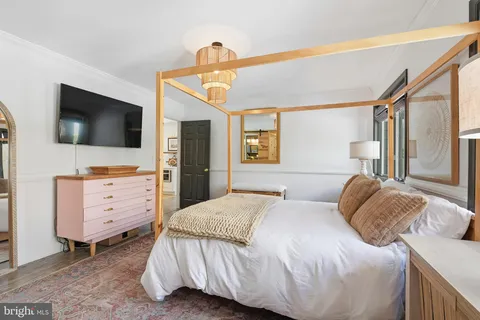 a bedroom with a bed and flat screen tv