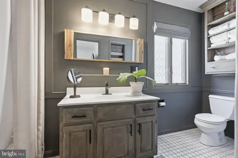 a bathroom with a toilet sink and mirror