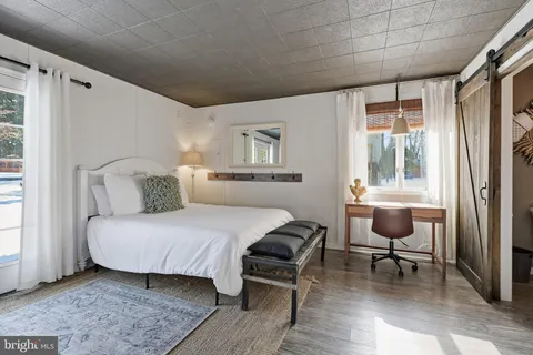 a bedroom with a bed couch and a window