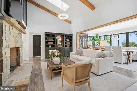 a living room with fireplace furniture and a floor to ceiling window