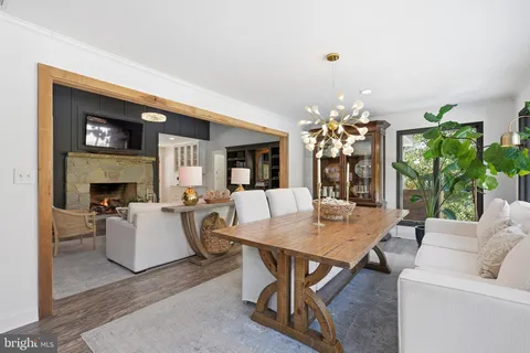 a living room with furniture a fireplace and a chandelier