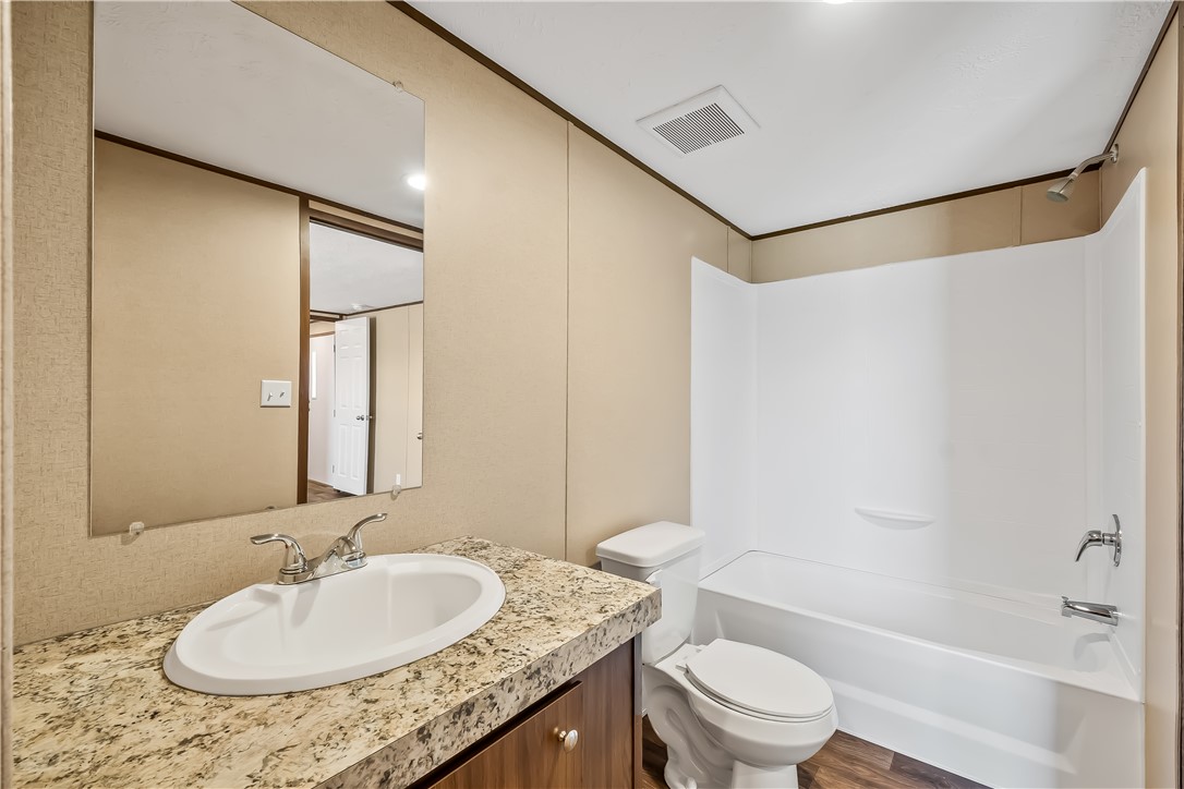 13205 South Water Reed Way Topock, AZ 86436 - Photo 24 of 37 a bathroom with a granite countertop sink a toilet a mirror and shower