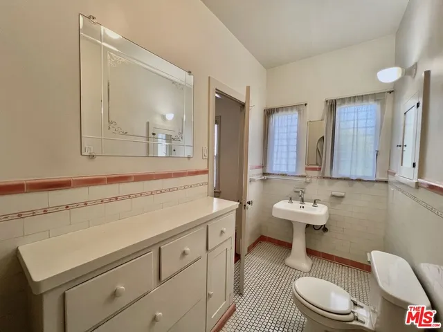 a spacious bathroom with a toilet sink and mirror