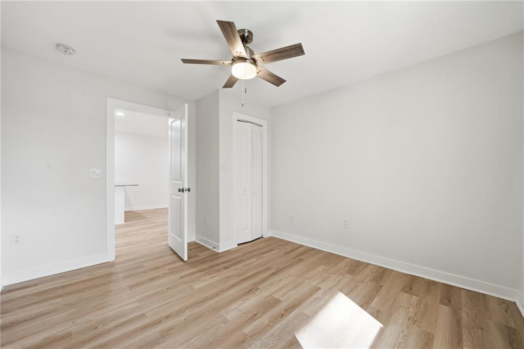 1136 Powell Court Southeast Atlanta, GA 30316 - Photo 14 of 33 an empty room with wooden floor and a ceiling fan