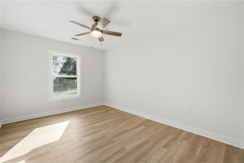 1136 Powell Court Southeast Atlanta, GA 30316 - Photo 17 of 33 an empty room with wooden floor chandelier fan and windows
