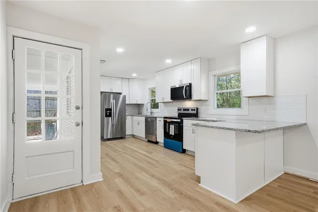 a kitchen with refrigerator cabinets and wooden floor