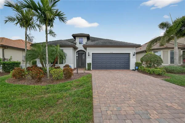 a front view of a house with garden and palm tree