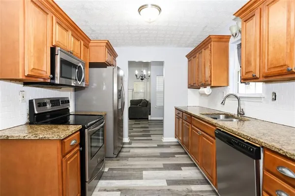 a kitchen with granite countertop a sink and a refrigerator