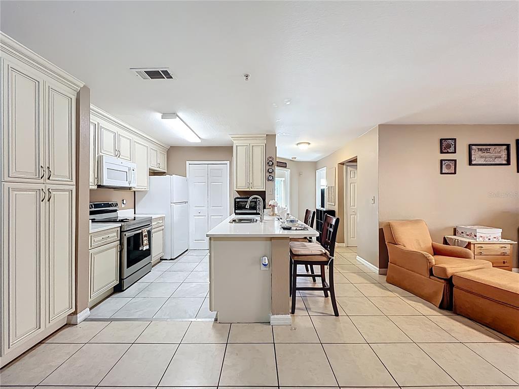 5471 Vineland Road, Unit 7109 Orlando, FL 32811 - Photo 11 of 60 a kitchen with stainless steel appliances a stove a sink a microwave and a refrigerator