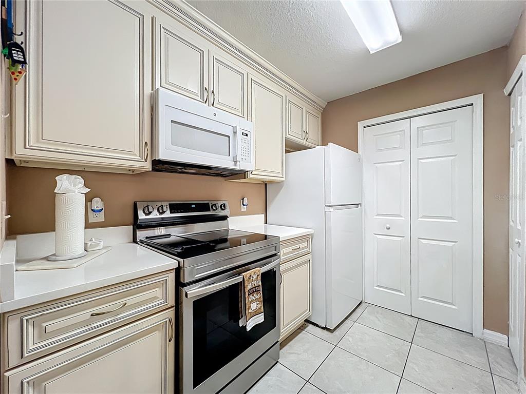5471 Vineland Road, Unit 7109 Orlando, FL 32811 - Photo 12 of 60 a kitchen with cabinets and steel stainless steel appliances