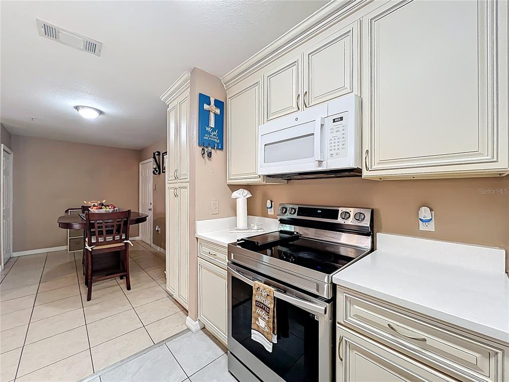 5471 Vineland Road, Unit 7109 Orlando, FL 32811 - Photo 13 of 60 a kitchen with stainless steel appliances granite countertop a stove and a refrigerator