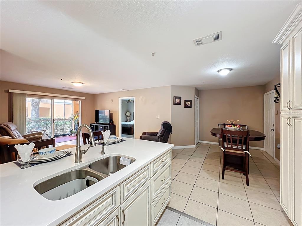 5471 Vineland Road, Unit 7109 Orlando, FL 32811 - Photo 15 of 60 a kitchen with a sink and chairs