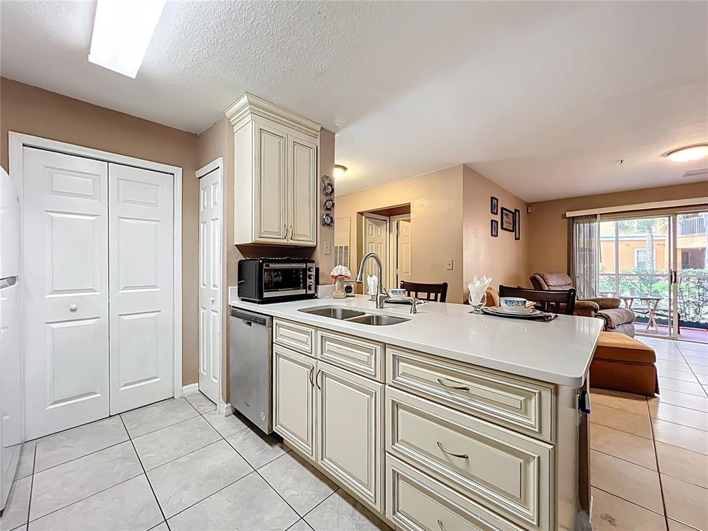5471 Vineland Road, Unit 7109 Orlando, FL 32811 - Photo 16 of 60 a large kitchen with kitchen island white cabinets and stainless steel appliances