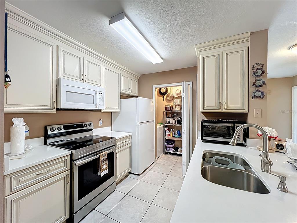 5471 Vineland Road, Unit 7109 Orlando, FL 32811 - Photo 17 of 60 a kitchen with granite countertop a sink a stove and refrigerator
