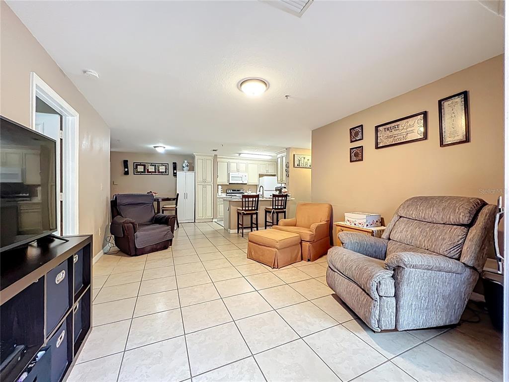 5471 Vineland Road, Unit 7109 Orlando, FL 32811 - Photo 25 of 60 a living room with furniture and a flat screen tv