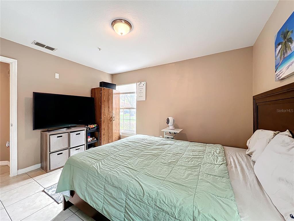 5471 Vineland Road, Unit 7109 Orlando, FL 32811 - Photo 26 of 60 a bedroom with a bed and a flat screen tv