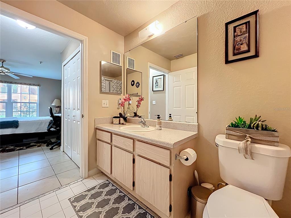 5471 Vineland Road, Unit 7109 Orlando, FL 32811 - Photo 36 of 60 a spacious bathroom with a granite countertop toilet sink and mirror