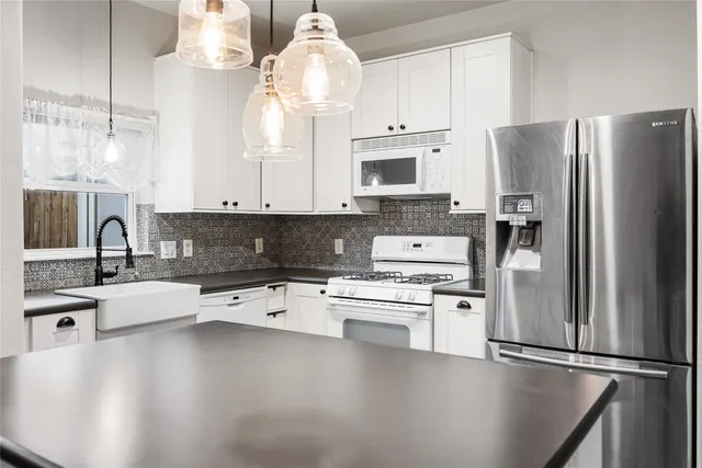 a kitchen with stainless steel appliances granite countertop a sink a stove and refrigerator