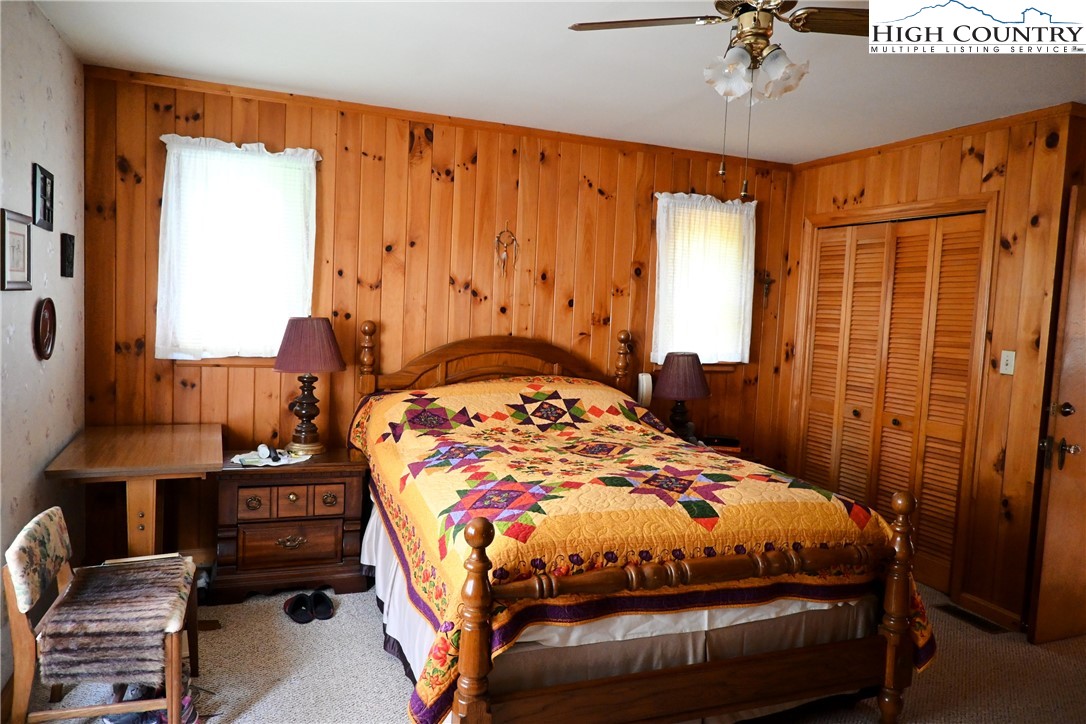 280 Smoky Hollow Road Laurel Springs, NC 28644 - Photo 16 of 42 a bedroom with a bed and wooden floor
