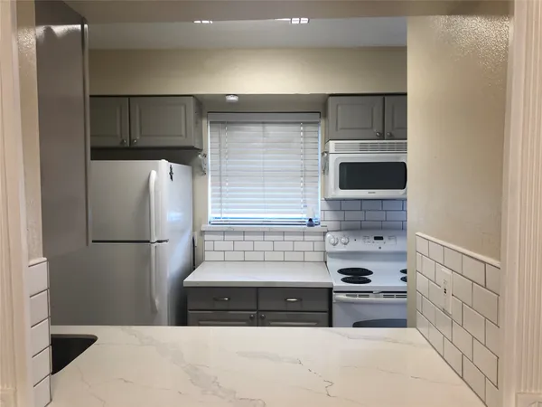 a kitchen with a refrigerator and a stove top oven