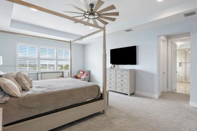 a bedroom with a bed tv and a large window