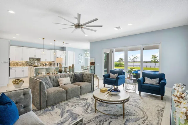 a living room with furniture and a view of kitchen