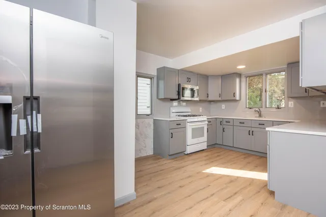 a kitchen with white cabinets and white appliances