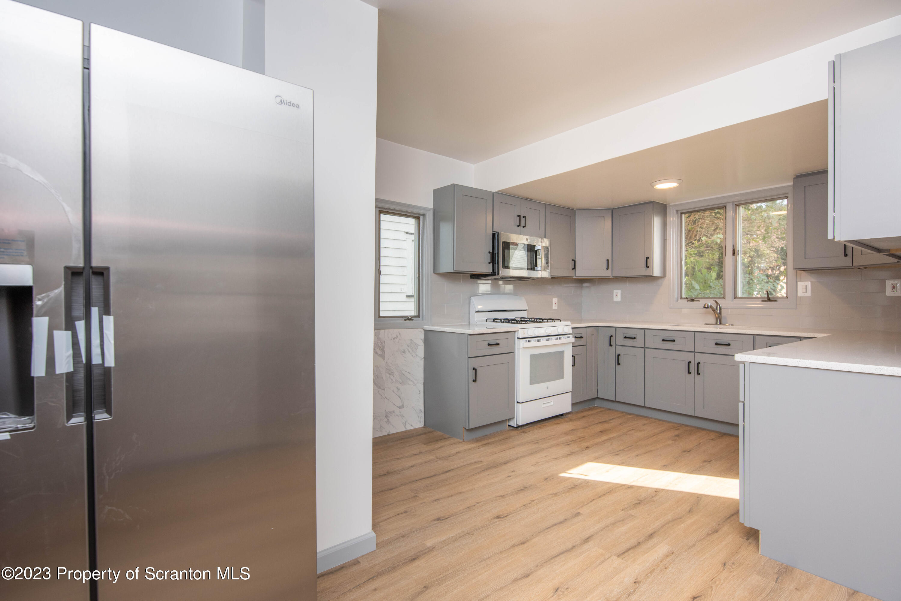 124 Delaware Avenue Olyphant, PA 18447 - Photo 11 of 30 a kitchen with white cabinets and white appliances