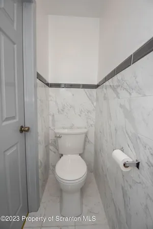 a white toilet sitting next to a shower