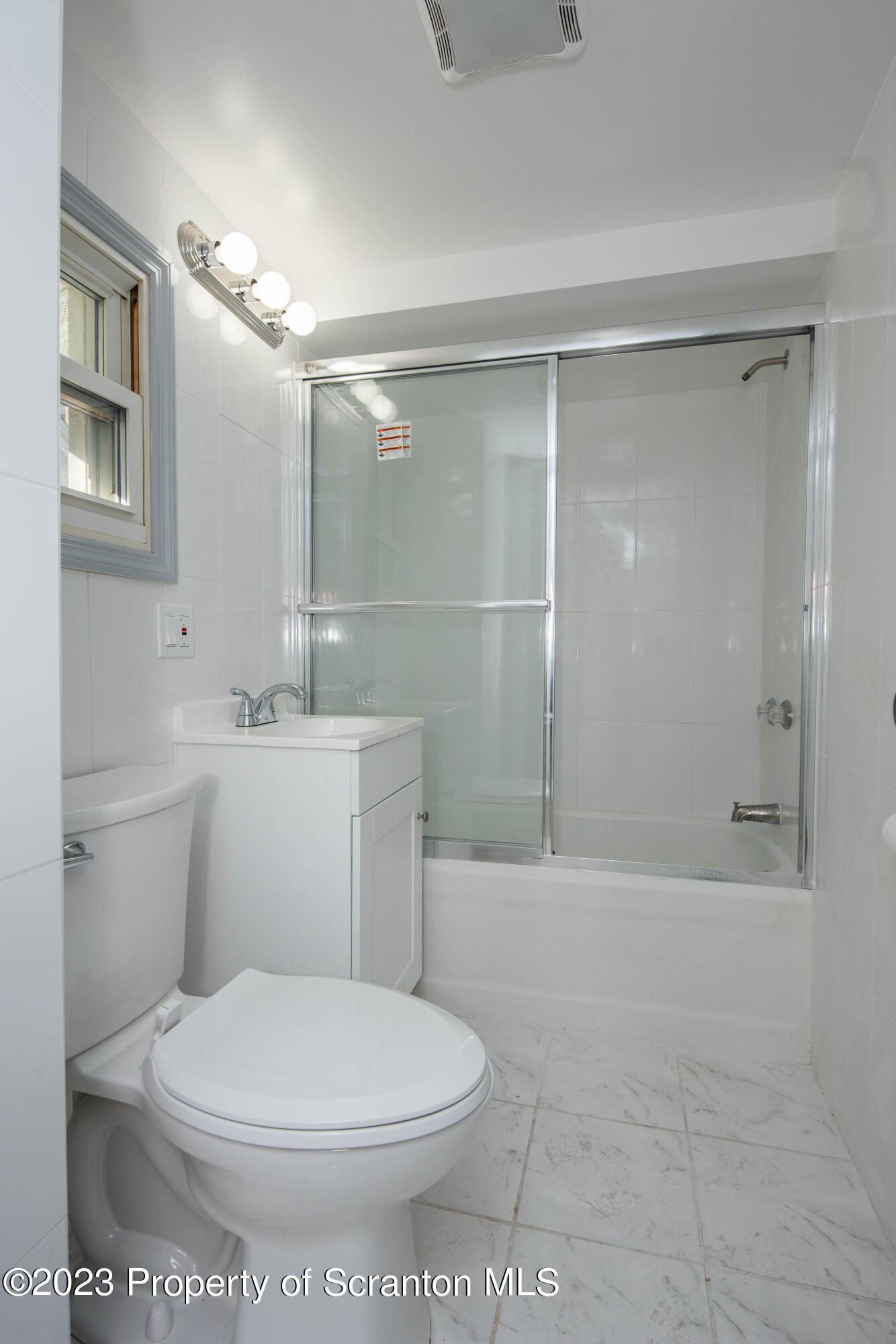 124 Delaware Avenue Olyphant, PA 18447 - Photo 14 of 30 a white toilet sitting next to a bathroom sink and a shower