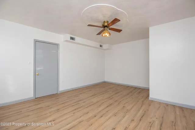 a view of a room with wooden floor and white walls