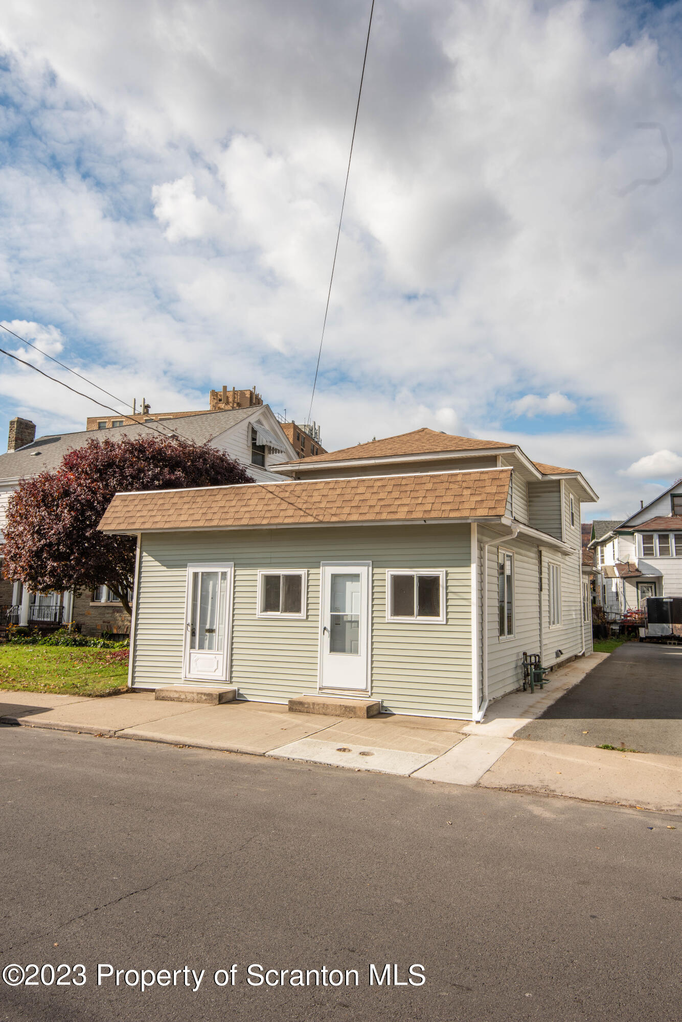 124 Delaware Avenue Olyphant, PA 18447 - Photo 23 of 30 a view of a white house next to a yard with big trees