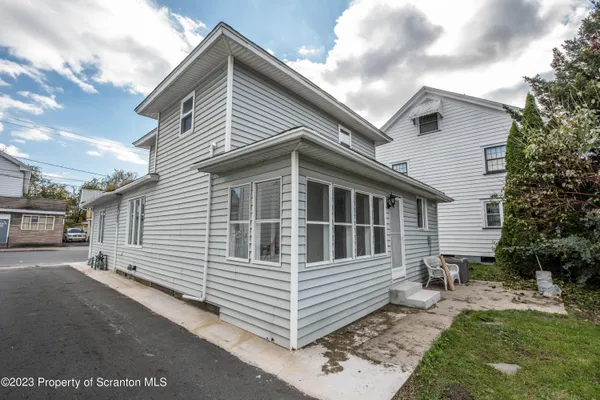 a view of a white house with a yard and stairs