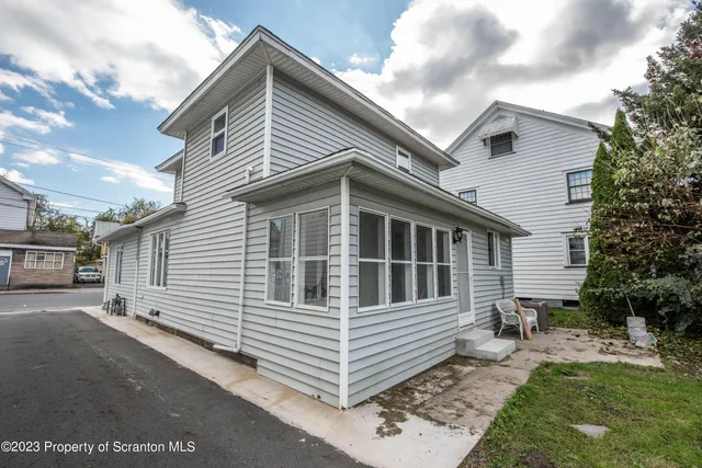 a view of a white house with a yard and stairs