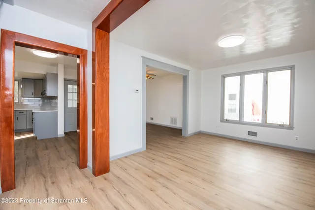 an empty room with wooden floor and a window