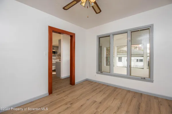 an empty room with ceiling fan and window
