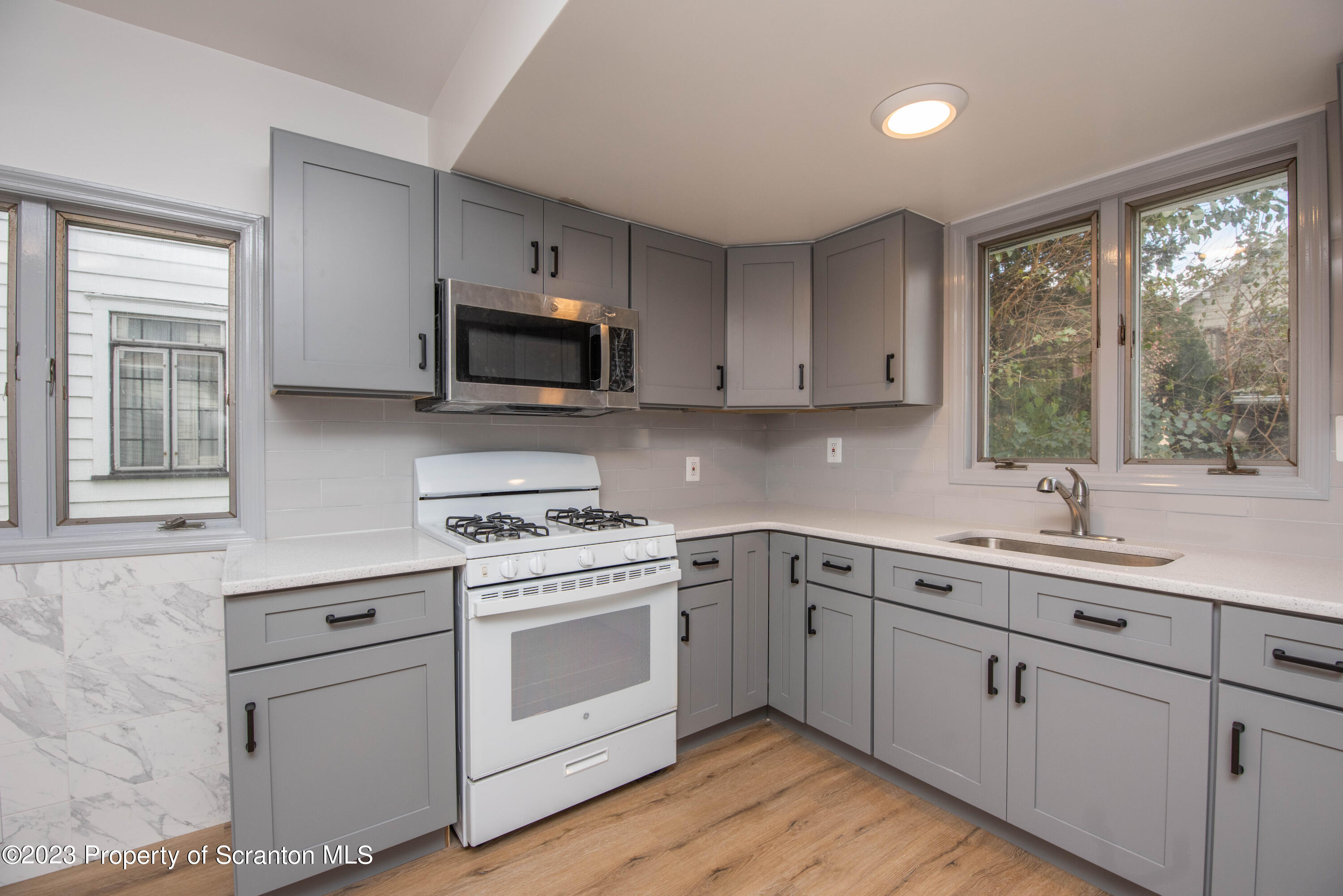 124 Delaware Avenue Olyphant, PA 18447 - Photo 8 of 30 a kitchen with white cabinets and white appliances