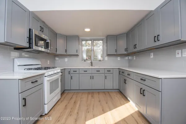 a kitchen with cabinets appliances and a window