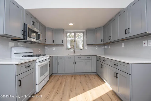 a kitchen with cabinets appliances and a window