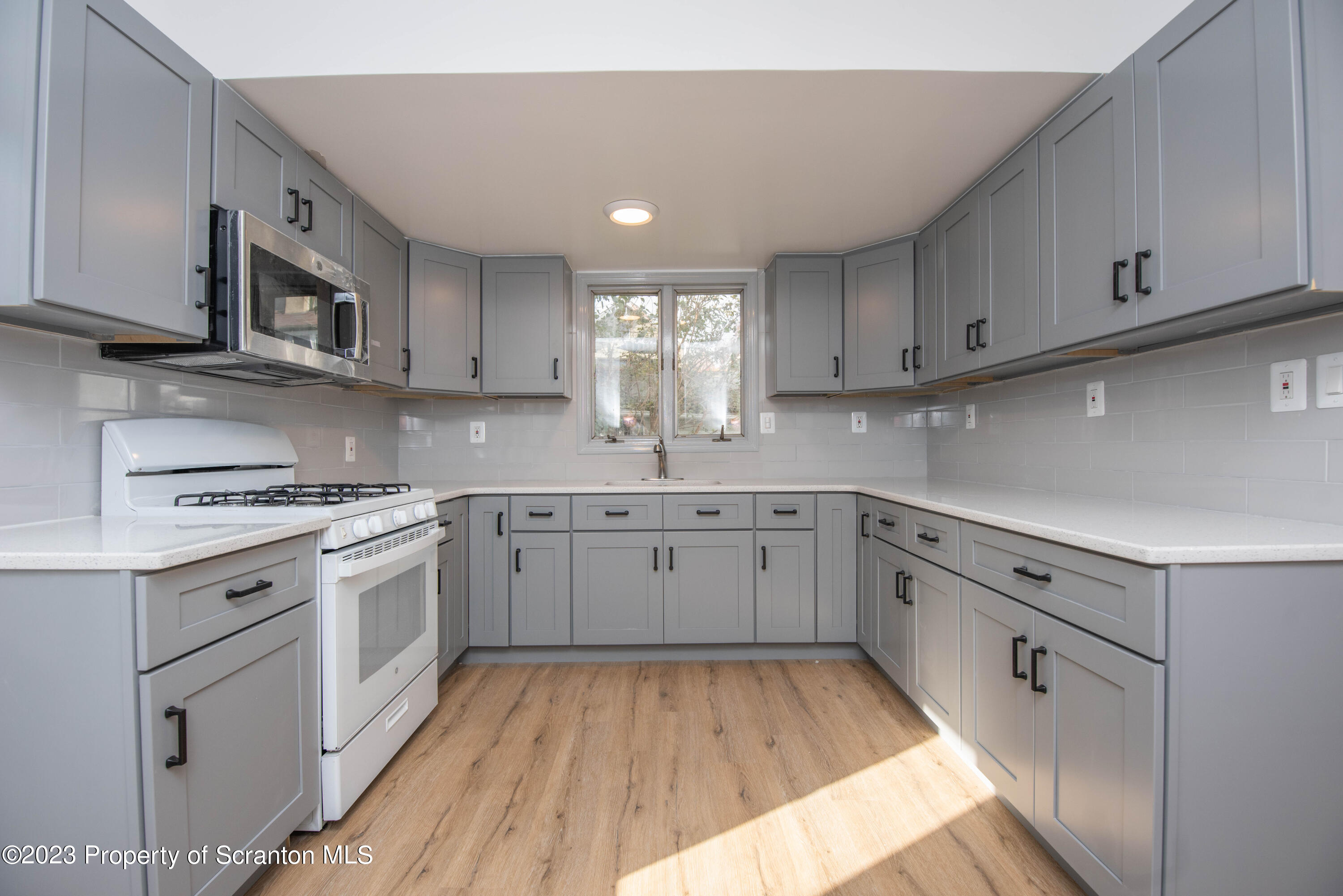 124 Delaware Avenue Olyphant, PA 18447 - Photo 10 of 30 a kitchen with cabinets appliances and a window