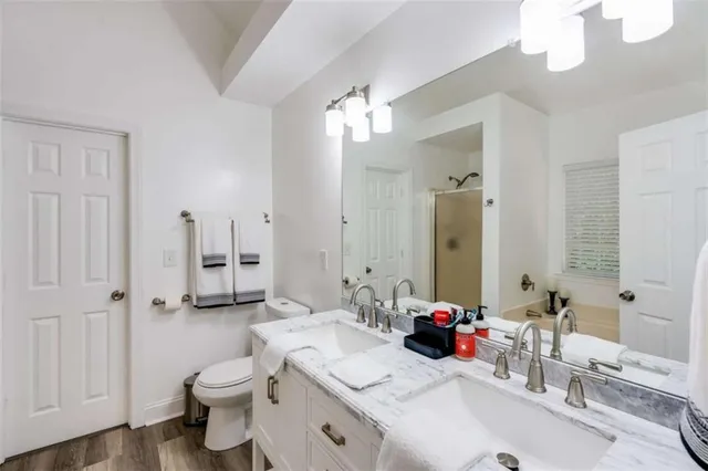 a bathroom with a double vanity sink mirror and toilet